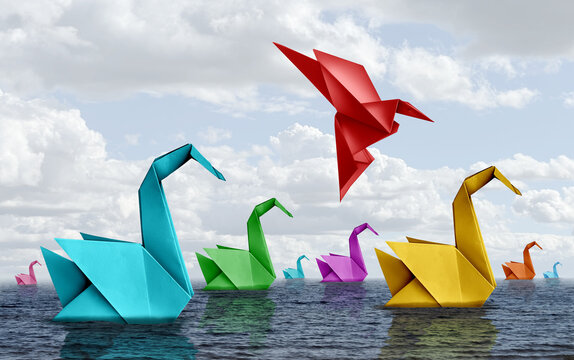 Changing your life concept and fearless courage symbol as diverse origami swans floating on water with a confident bird rising up and flying away as business confidence or fearlessness