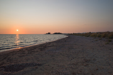 Sunset over Ionian Sea, twilight on wild beach near island of Lefkada, Greece