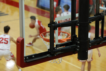 high school basketball action seen through a backboard.