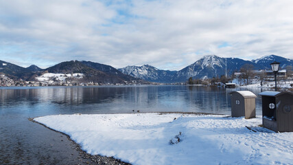 La jetée de Bad Wiessee et le sentier de promenade enneigé au bord des eaux calmes du lac de...