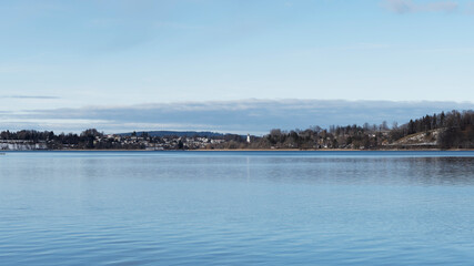 Lac de Haute-Bavière. Vue sur le lac de tegern et à l'horizon, la plage de Kaltenbrunn à Gmund am Tegernsee et le clocher de l'église St. Ägidius depuis la jetée et la promenade du lac à Bad Wiessee