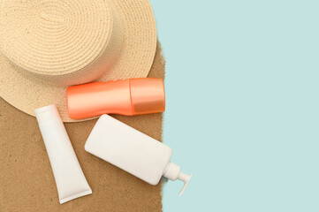 The concept of summer holidays at sea. Straw hat and protective cream.