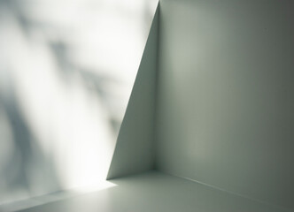 Illumination of natural light and shadow on a white room surface with free space.