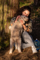Young woman petting dog in forest