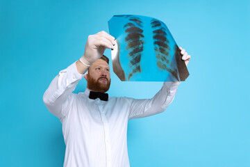 Studio shot of sport referee wearing white shirt and butterfly tie isolated on blue studio...