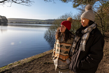 Female friends standing at lake