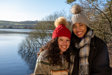 Obraz premium Portrait of female friends standing at lake