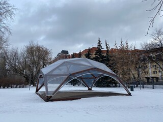 Wooden modular structure in the form of a dome. The building stands on the ground in the center of...