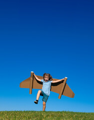 Kid pilot with toy jetpack against sky background. Happy child playing outdoors. Happy childhood. Children imagination concept.