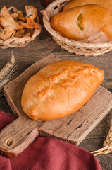 Appetizing fresh culinary pastry - filled patty on wooden