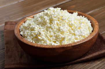 Homemade curd cheese in wooden bowl