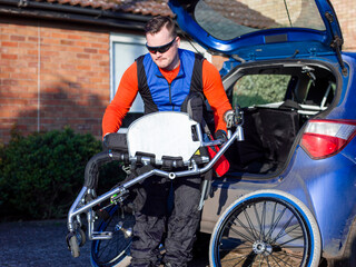 Fototapeta na wymiar Disabled man setting up handcycle at car