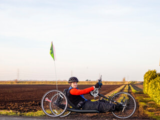 Portrait of disabled man on handcycle in rural landscape