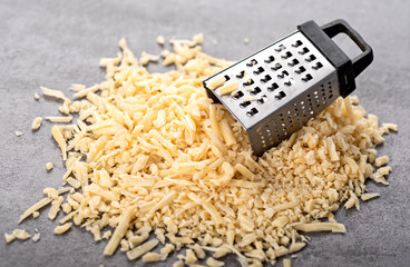 A mound of grated parmesan with a small grater