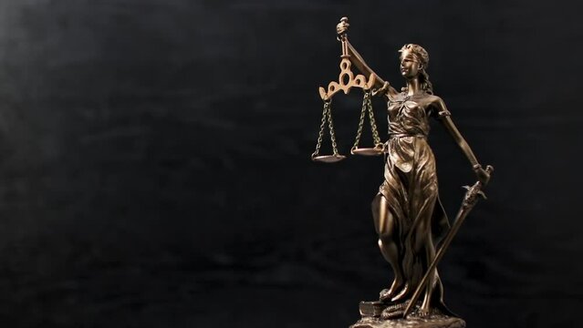 Bronze statue of themis or lady of justice on black background. Legal law.