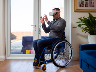 Man on wheelchair with VR goggles at home
