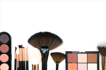 Obraz na płótnie Canvas Decorative cosmetics and makeup brushes on a white isolated background, top view. place for your text
