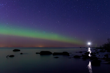 Arcuate aurora green above the lake with lighthouse