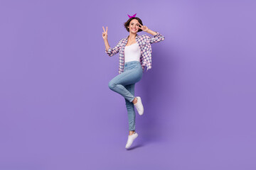 Fototapeta na wymiar Photo of adorable cute woman wear plaid shirt jumping high v-sign cover eye isolated violet color background