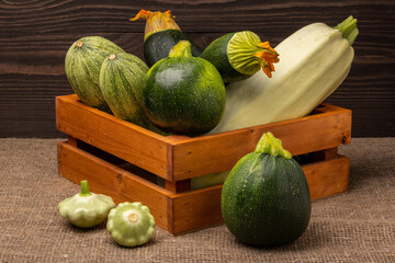 zucchini and squash in a box on a wooden table