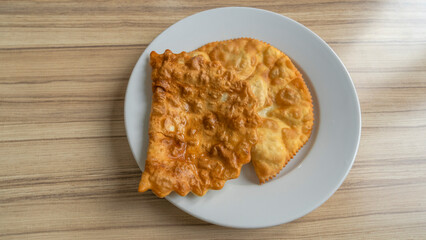 Top view of homemade pasties with meat filling on white plate. Take away food concepts. Street food background.