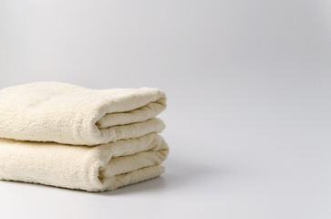 A stack of clean white towels on a white background with a place to demonstrate shampoo, cosmetics, soap