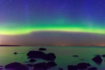 Arcuate aurora green above the lake with moon