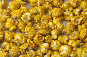 A pile of delicious popcorn on a white background. Scattered popcorn texture background. Selective focus.