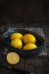 Lemons in an iron basin in a mood style and rustic.