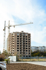 Fototapeta na wymiar Construction cranes and buildings under construction against the blue sky. New building