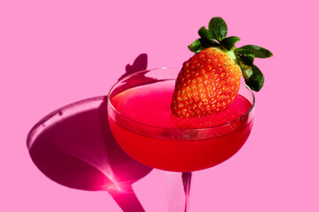 sweet jelly dessert in a glass cup with natural strawberries on a pink background
