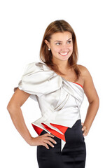 Smiling beautiful young woman in black white red dress, standing and looking at camera. Studio shot, cropped mid-thigh, isolated on white
