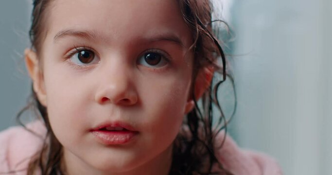 Cute toddler girl posing in pink robe after a bath. 4K footage.