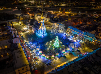 Aerial panoramic drone photo of Kaunas Old Town with a Christmas market and a Christmas tree with decorations at night