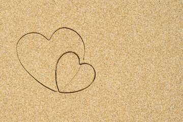 Hand-drawn shape of two heart on sand tropical beach. valentines day. Holiday concept. Creative, background, copy space, travel, summer. Flat lay