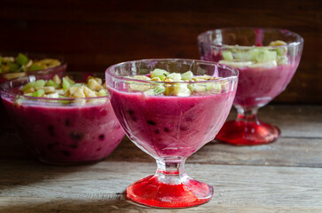 Homemade fruit dessert in a glass cup, on a wooden table.