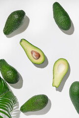 Whole ripe eco avocados on a white background. High key. Avocado slices top view.