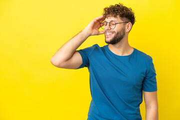 Fototapeta na wymiar Young handsome caucasian man isolated on yellow background smiling a lot