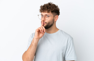 Young handsome caucasian man isolated on white background With glasses and doing silence gesture