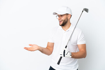 Handsome young man playing golf  isolated on white background with surprise expression while looking side