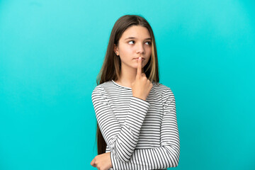 Obraz premium Little girl over isolated blue background having doubts while looking up
