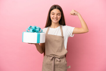 Little girl with a big cake over isolated pink background doing strong gesture