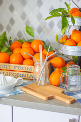 Freshly squeezed mandarin orange juice with glass pitcher, glass jars and aluminum reusable straws.
