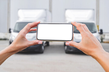 Smartphone mockup in female hands. Against the backdrop of trucks. Logistics concept.
