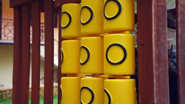 Tic Tac Toe game on playground equipment in the park. girl plays tic-tac-toe. Tic-tac-toe on the playground. The girl rotates cylinders with crosses.