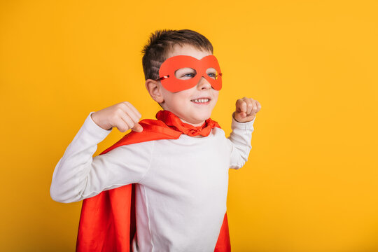 Boy in superhero outfit showing muscles