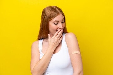 Young redhead woman wearing a band-aids isolated on yellow background with surprise and shocked facial expression