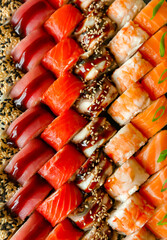 Assorted japanese sushi rolls on black background.