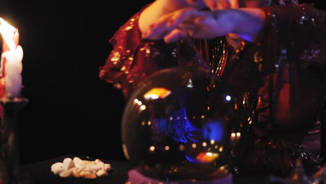 Hands of a fortune teller in a magical read the future in a crystal ball. Overall plan