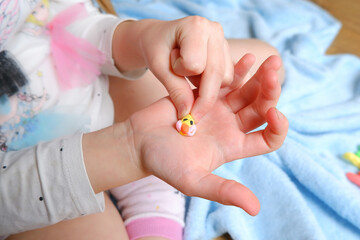 colored plasticine figurine on a child's hand